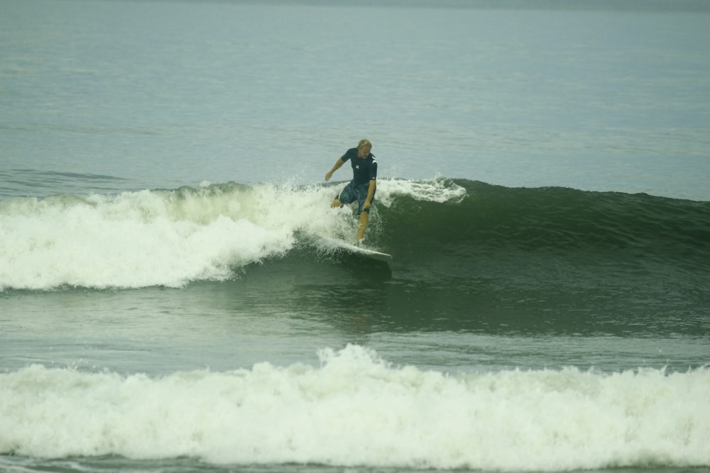 Stefan von ServerBase beim Surfen auf einer Welle im Meer.